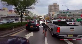 Экстремал велосипедист в уличном потоке