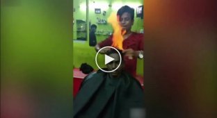 В Индии парикмахер использует огонь, чтобы подстричь своего клиента
