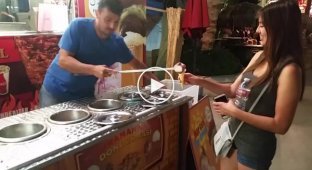 Весёлый продавец мороженого отдает девушке заказанный рожок