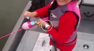 Маленькая девочка поймала большого окуня на детскую удочку