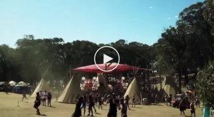 Участники австралийского фестиваля Earthcor танцуют возле песчаного торнадо