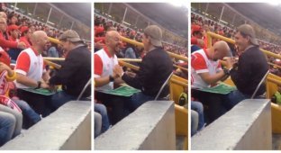 Слепой мужчина с помощью своего друга наслаждается игрой любимой футбольной команды (2 фото)