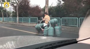 Китаец загрузил 7 газовых баллонов на свой скутер