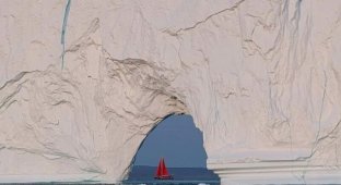 Крошечная лодка проплывает возле огромного айсберга (4 фото)