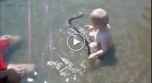 Малыш играет со змеей