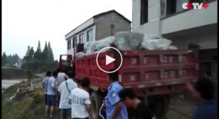 В Китае для ликвидации прорыва дамбы в воду сбрасывали грузовики с камнями