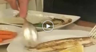 Официант убирает кости из рыбы