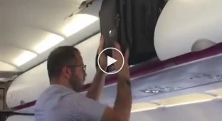 Пассажир самолёта пытается запихнуть свой чемодан