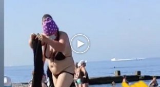 Странная женщина на пляже тепло оделась и пошла плавать