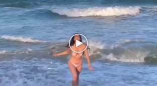 Девушка бежит с моря на берег