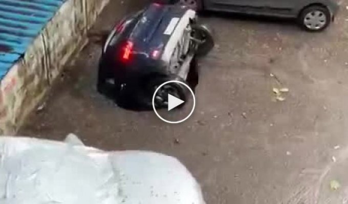 В Индии после сильных дождей прямо на парковке машину засосало под землю