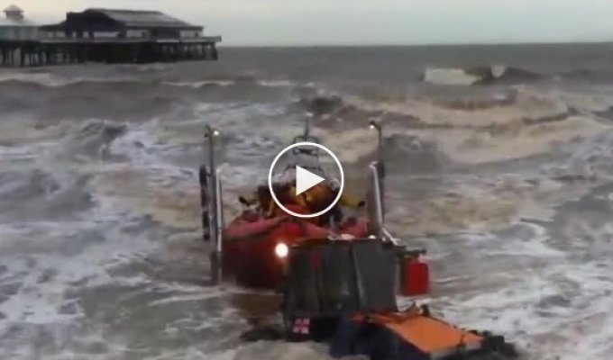 Трактор вытаскивает на берег британскую спасательную лодку