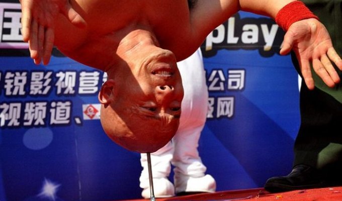 Каскадер Ли Синь из Китая простоял на голове 10 секунд на шипе (3 фото)