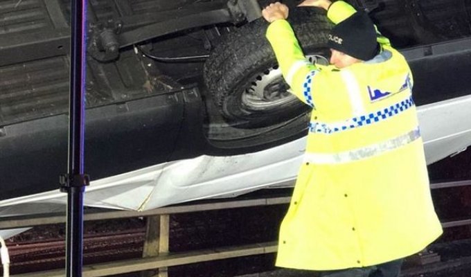 В Великобритании полицейский удерживал автомобиль, зависший на краю моста (2 фото)