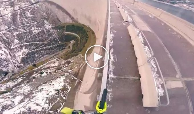 21-летний экстремал балансирует на своём велосипеде на перилах 200-метровой дамбы