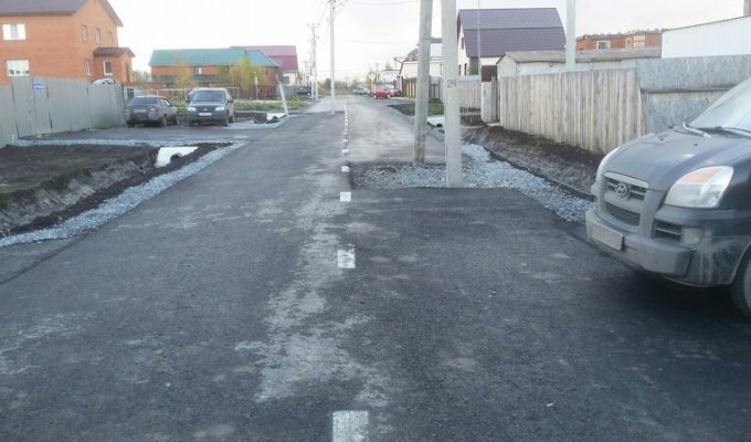 В Тюмени заасфальтировали дорогу, по середине которой стоят столбы (2 фото)