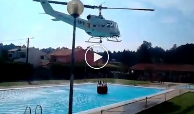 Пожарный вертолет берет воду из бассейна