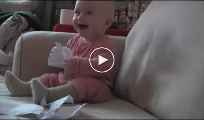 Ребенок смеется от порванной бумаги