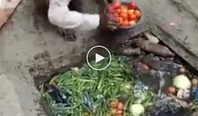 Пакистан. Уличный торговец тщательно моет от пыли и грязи овощи перед продажей