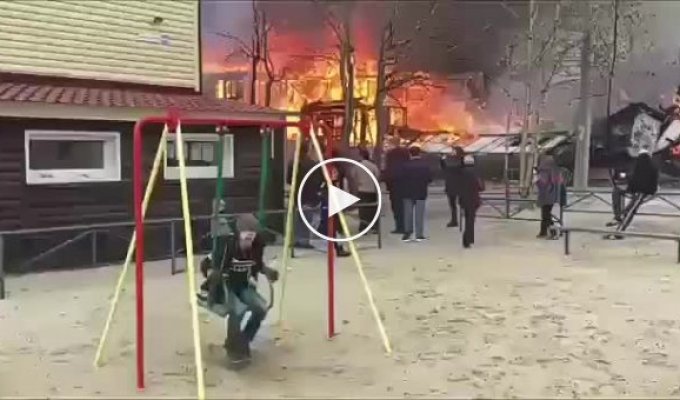 Невозмутимый мальчик на качелях рядом с пожаром в Ноябрьске