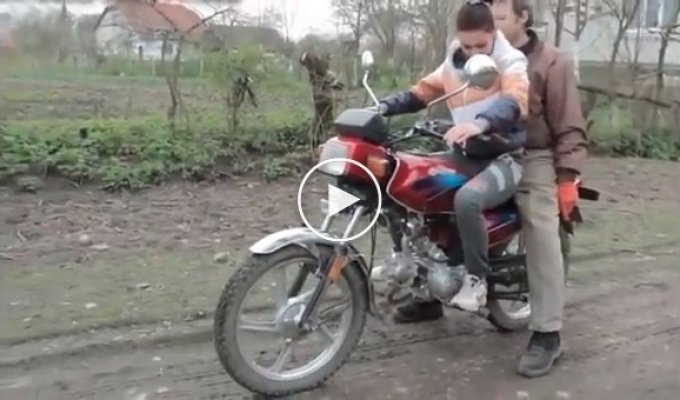 Отец учит дочь кататься на мотоцикле
