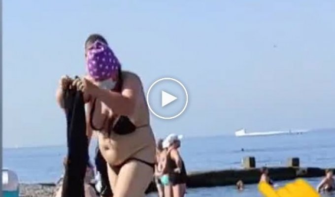 Странная женщина на пляже тепло оделась и пошла плавать