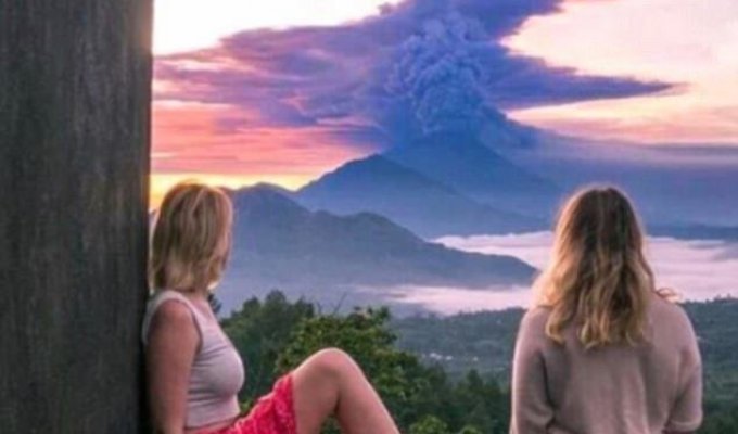 Пока жители Бали уезжают подальше от вулкана, туристы фотографируются на фоне выбросов пепла (13 фото)