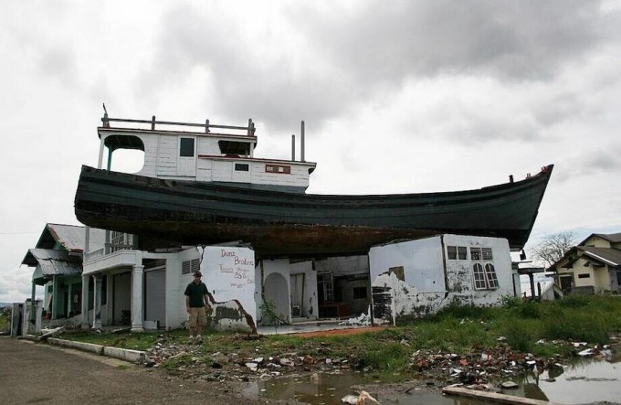 Почему в городе Индонезии много лет стоит лодка на крыше дома и баржа посреди города (5 фото)