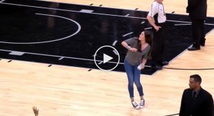 A basketball player skillfully throws a souvenir T-shirt to a spectator