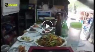 Корейский официант носит на голове обеденный стол заставленный блюдами