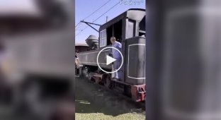 A tourist train driver kicks a careless woman away