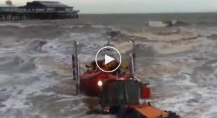 Трактор вытаскивает на берег британскую спасательную лодку