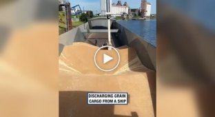 Unloading a barge with grain with a vacuum unloader