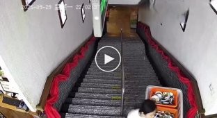 Спроба дівчини спустити контейнер з посудом з сходів