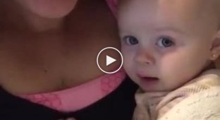 Mom sings “I love you” to the girl, and the baby tries to repeat it