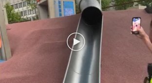 The policeman decided to ride down the children's slide and almost broke his neck