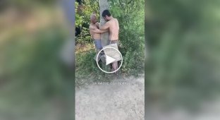 Российский солдат бьет палкой двух своих соратников, привязанных к столбу