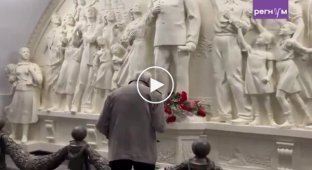 Пожилой россиянин крестится и кланяется перед памятником Сталину в московском метро