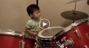 One year old child plays drums