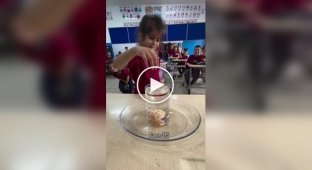 Дети пытаются достать мандарин из стакана с водой