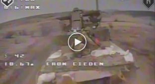 Росіянин, що їде на броні танка, намагається збити дрон, кинувши в нього автомат