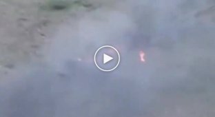 Двоє палаючих окупантів вилазять із бронемашини, що горить.