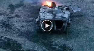 A Ukrainian drone operator watches the crew of a Russian BMP-1 sunbathe under a damaged and burning vehicle