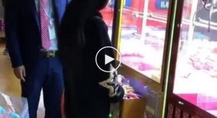Девушка сломала систему и вытаскивает игрушку за игрушкой из игрового автомата