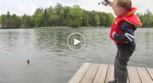 Маленький мальчик поймал первую рыбку