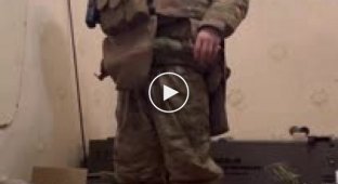 Солдат ЗСУ показує свій комплект зимового бойового одягу, американської системи EcWCS