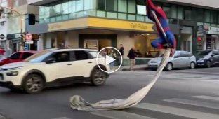 An eccentric in a Spider-Man costume entertains passers-by