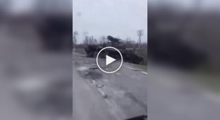 Оккупанты едут по дороге, вдоль которой лежат остатки разбитой техники армии РФ