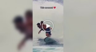 A surfer catches a wave with his son