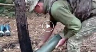 Ukrainian soldiers remove a 120mm mortar shell from a launcher that failed to fire.